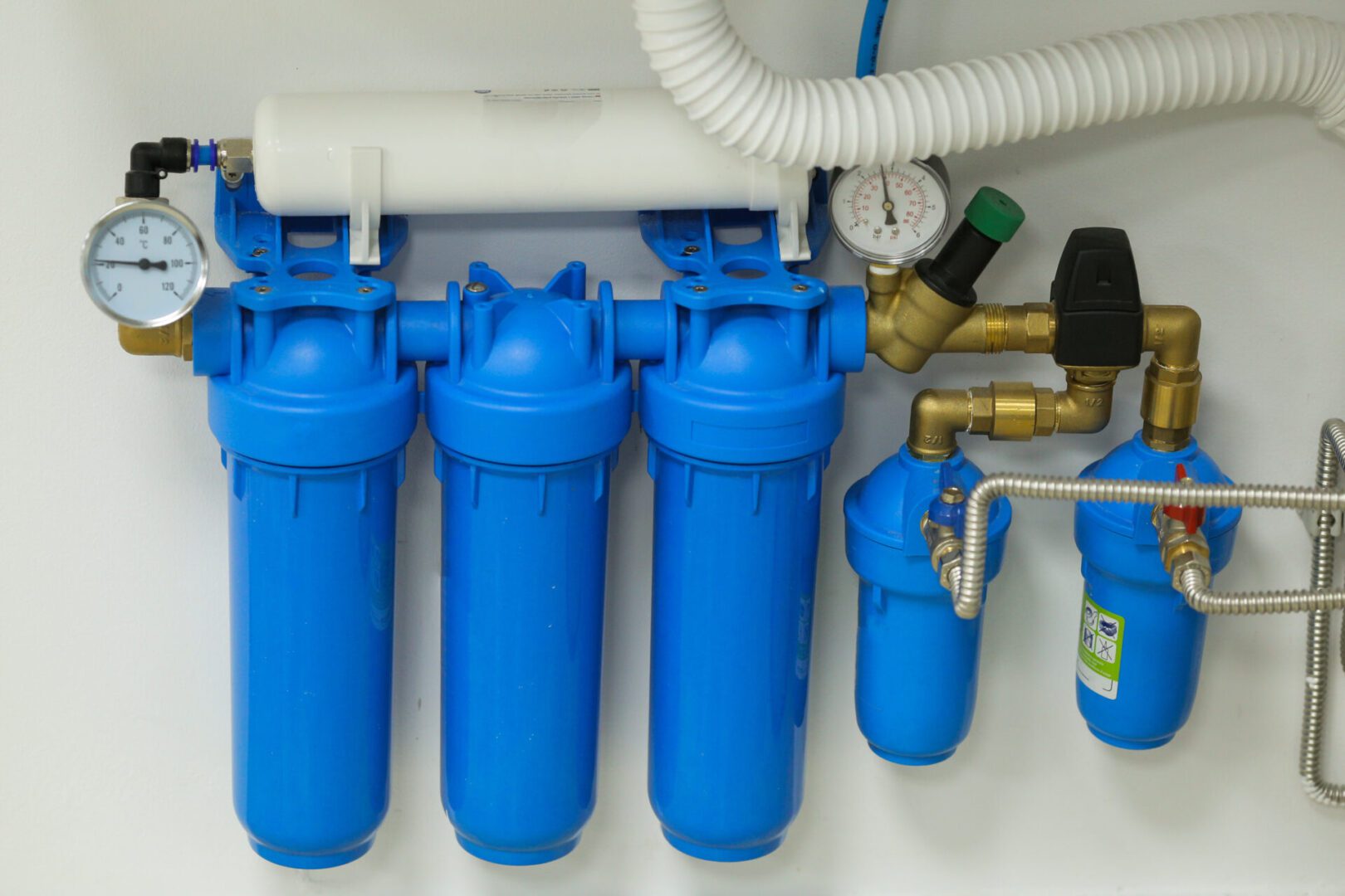 Blue water filtration system with pressure gauges.