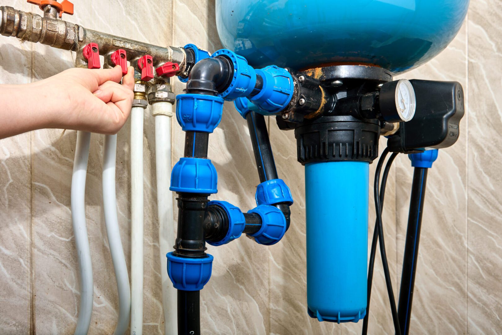 Hand adjusting water filtration system valves.